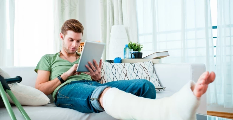 mężczyzna z&nbsp;nogą w&nbsp;gipie